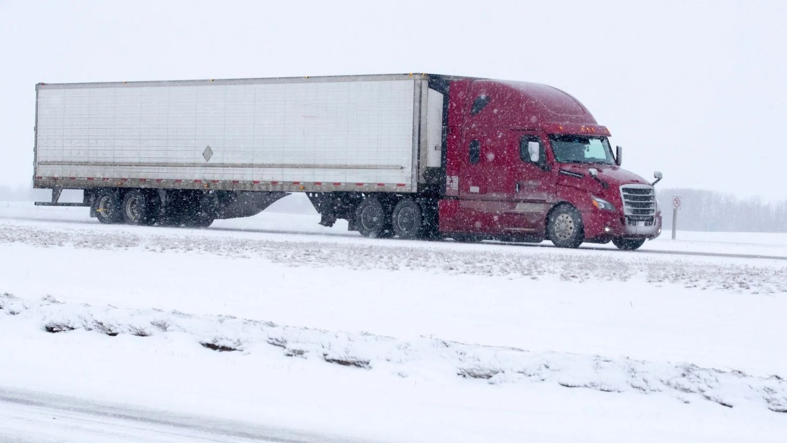 Commercial truck covered in road salt and winter grime on an Ontario highway