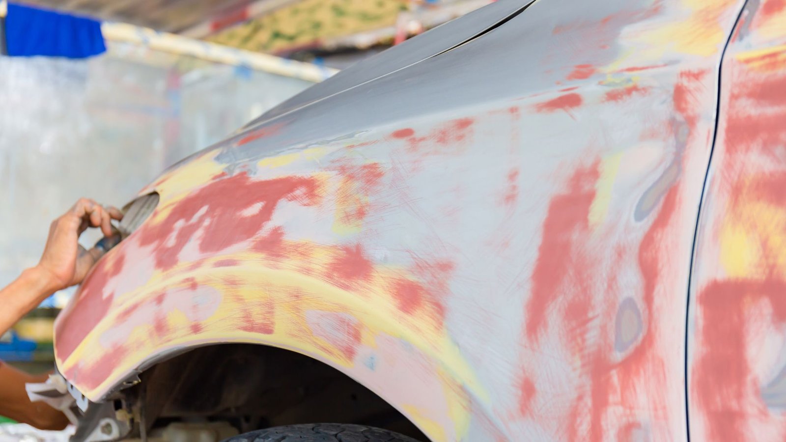 Technician performing minor body repair on a commercial truck panel